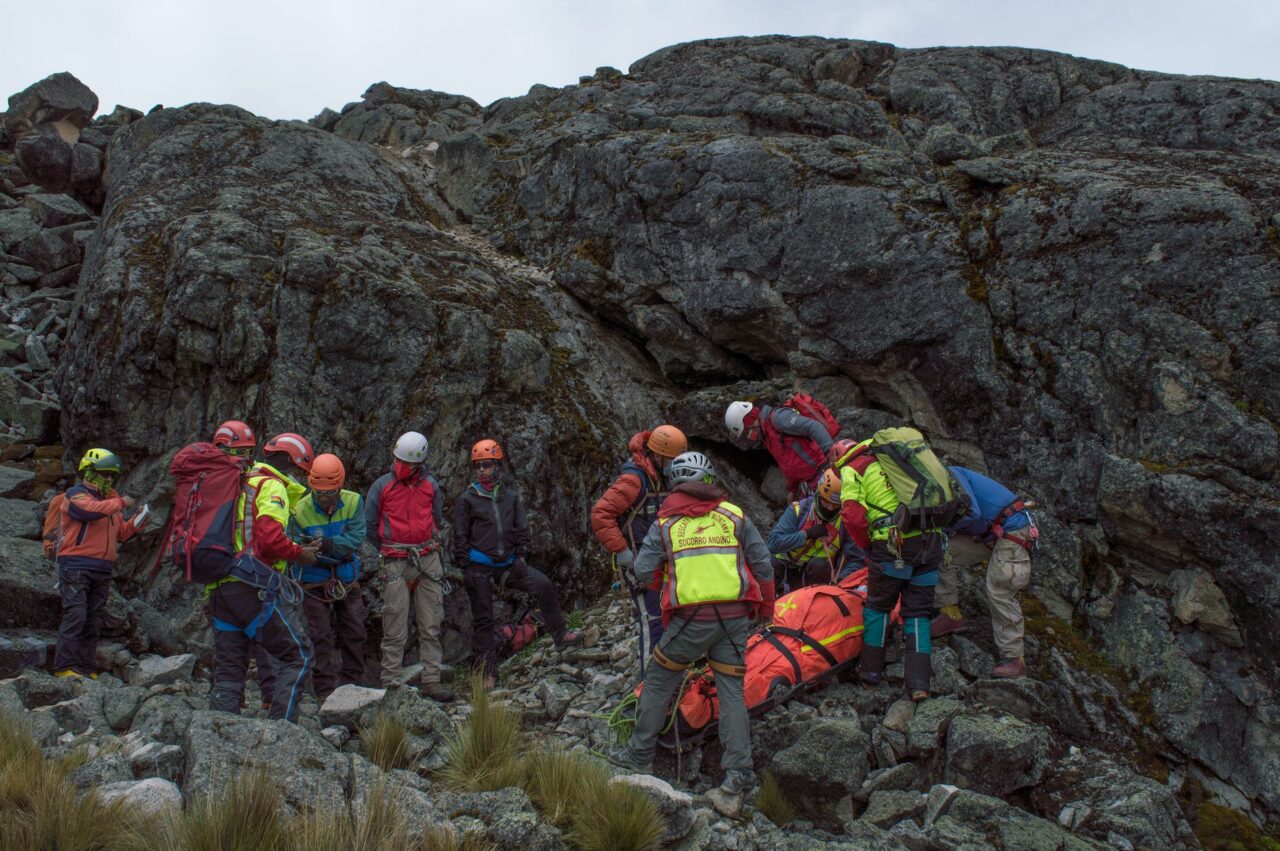 group of people in red jacket standing on brown rock formation